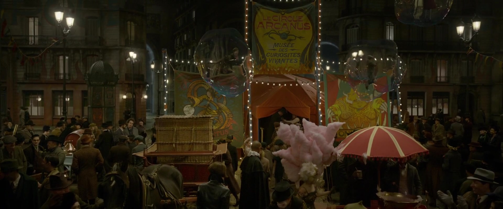 What Is Art Nouveau? Definition, Style, Artists & Film Influence 8 A crowded night street scene with a circus entrance, string lights, large illustrated posters, a banner reading “Le Cirque Arcanus,” and people gathered around carts and stalls.