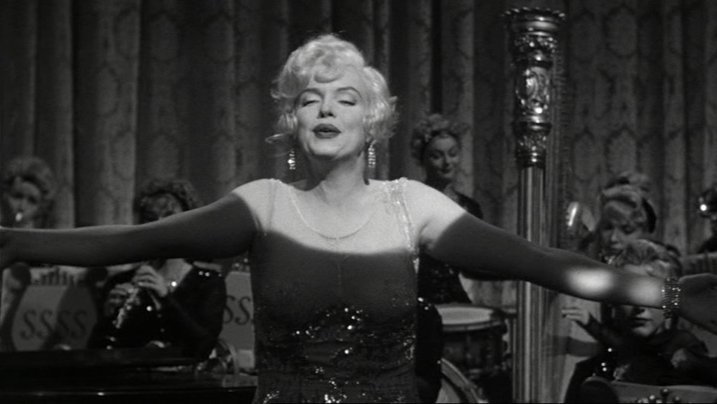 30 Films Every Budding Film Student Should Watch & Why 26 A blonde woman in a sequined dress sings on stage with her arms outstretched, backed by an all-female band.