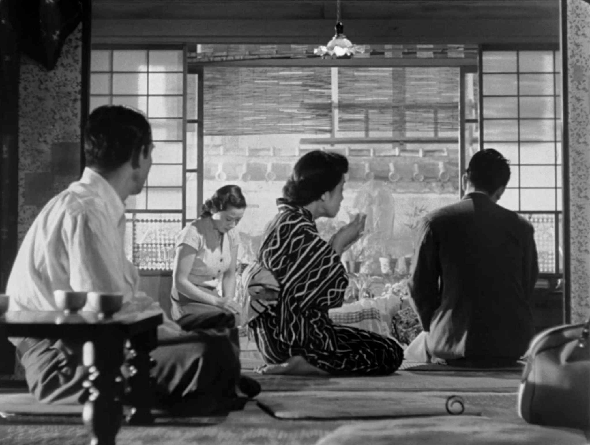 30 Films Every Budding Film Student Should Watch & Why 4 Four people sit on the floor inside a Japanese home, framed by sliding doors, with figures positioned in the foreground, midground, and background.