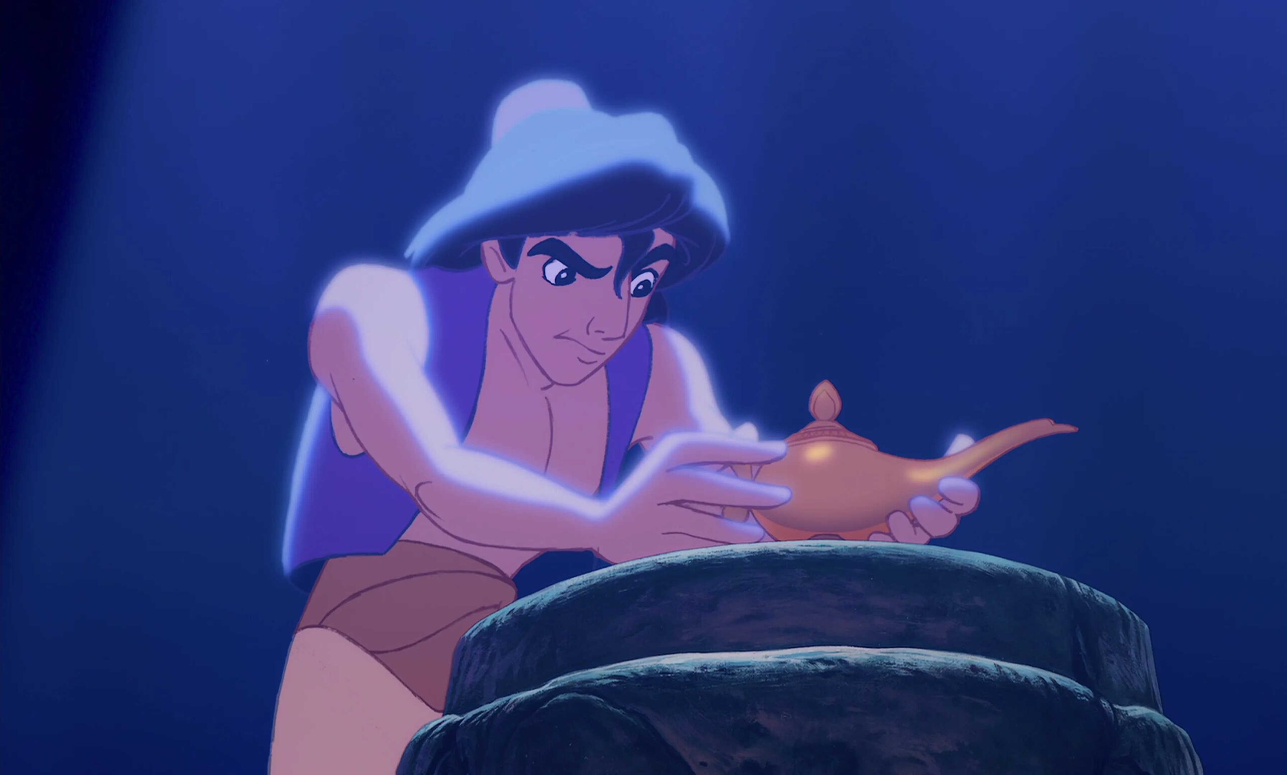What Is A MacGuffin? Definition + Good & Bad Examples Explained 8 Aladdin reaches out to grab the glowing magic lamp from a stone pedestal in a dark cave.