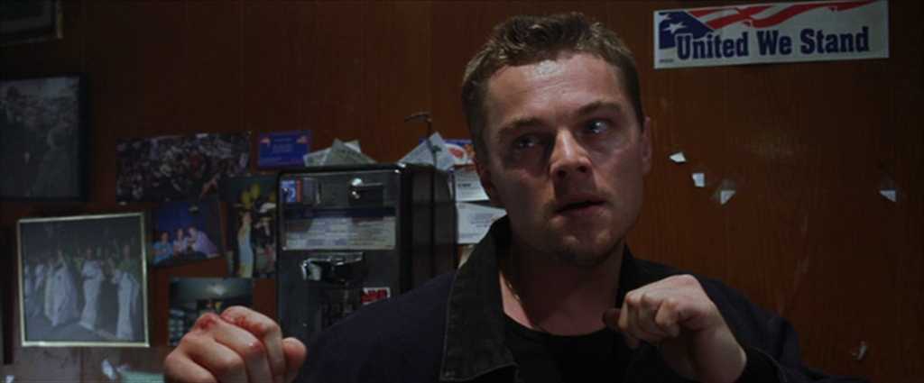 10 Best Gangster Movies of All Time For Filmmakers To Watch 10 Billy stands tense with raised fists in a small room covered in photos and a “United We Stand” sticker