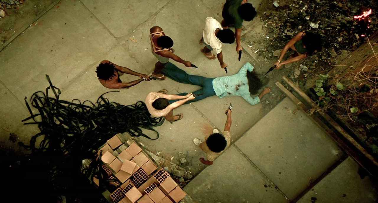 10 Best Gangster Movies of All Time For Filmmakers To Watch 4 Overhead shot of a man lying dead as a circle of boys point guns at him in an alley
