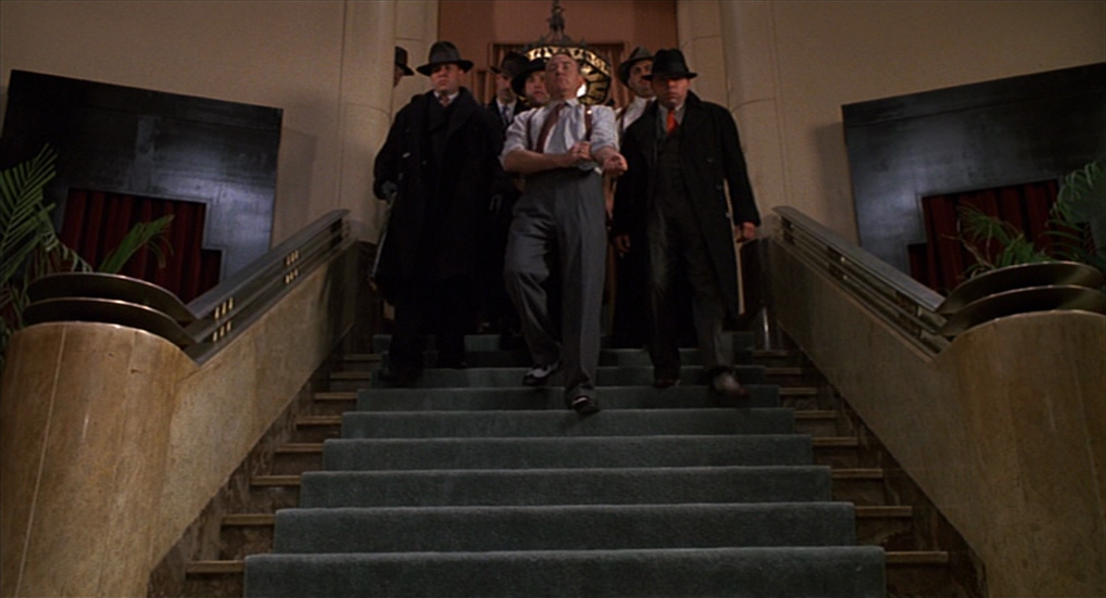 10 Best Gangster Movies of All Time For Filmmakers To Watch 9 Johnny Caspar descends a grand staircase flanked by suited mobsters in an Art Deco lobby