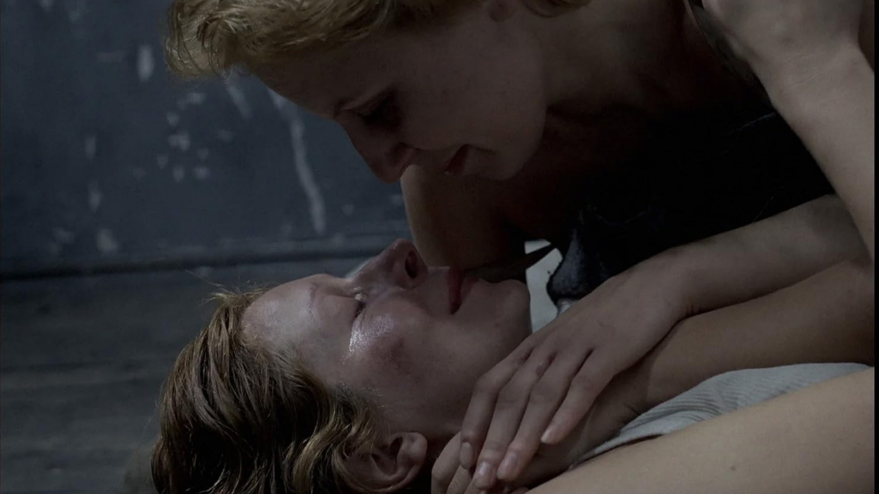 Sexy Female Prison Movies Too Taboo For Today's Audience 12 Two women lie close together in a prison cell, one comforting the other, in Interrogation (1989)