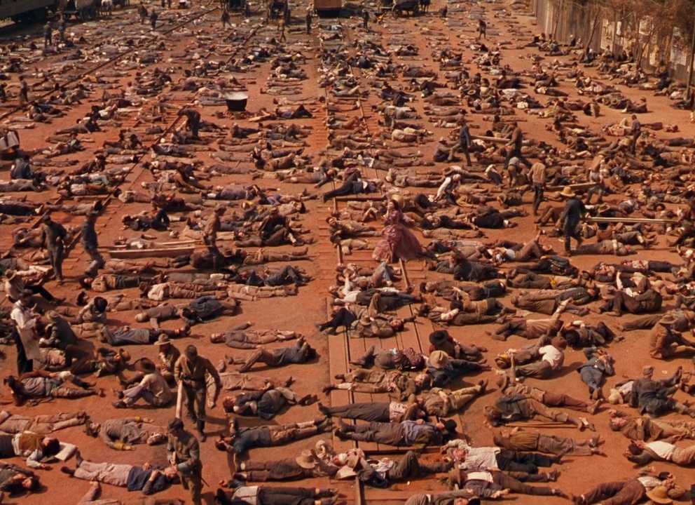 What is Imagery? Definition & Examples from Film 4 Wide view of a rail yard crowded with wounded soldiers while Scarlett O'Hara appears small among them.