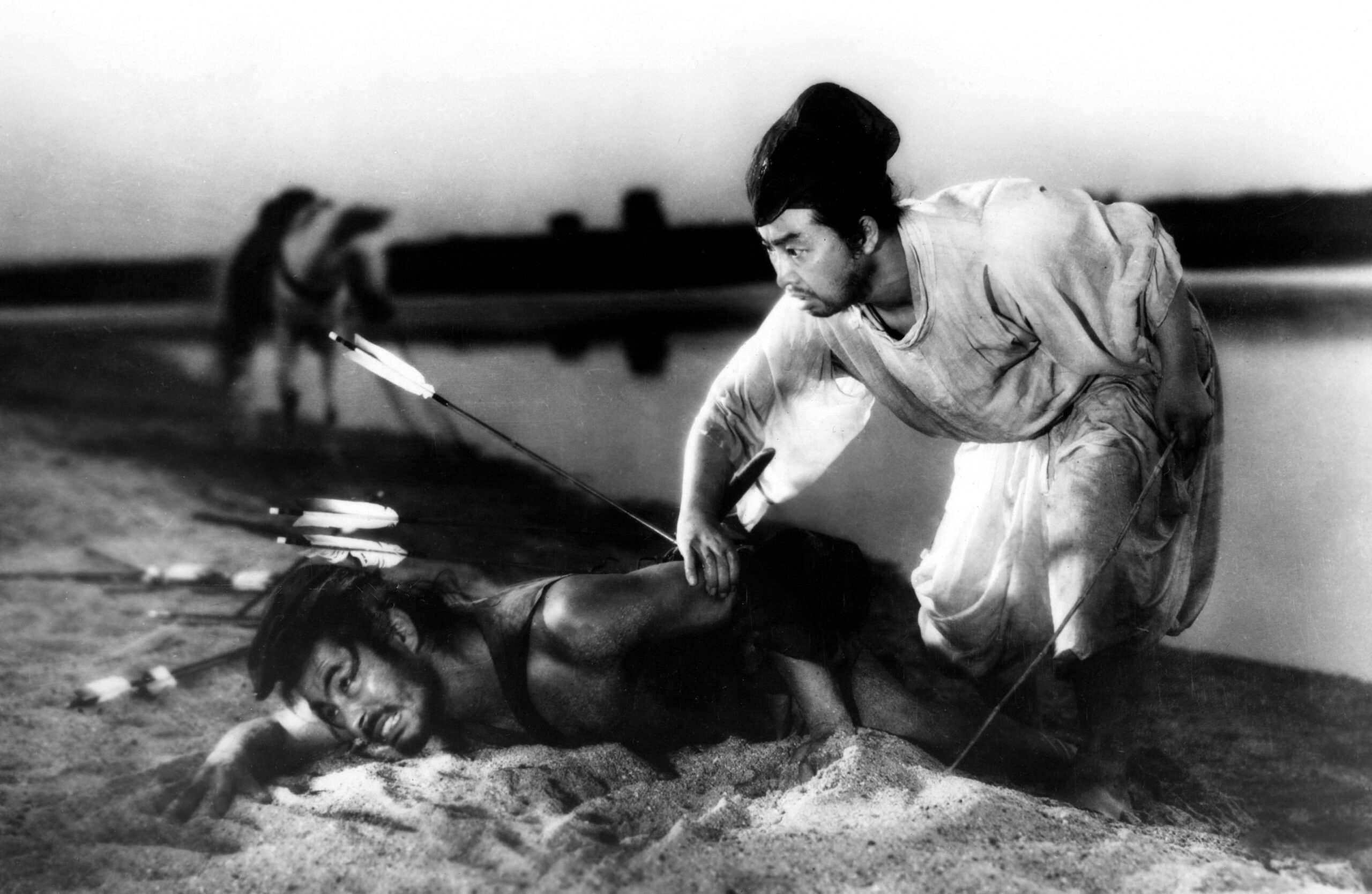 Context in Screenwriting and Film: A Complete Guide 9 A wounded man lies in the sand with arrows in his back as another man crouches beside him in traditional robes