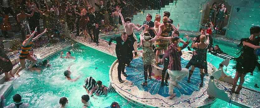Context in Screenwriting and Film: A Complete Guide 2 Party guests in flapper dresses and tuxedos dance, swim, and throw confetti around an ornate pool at night