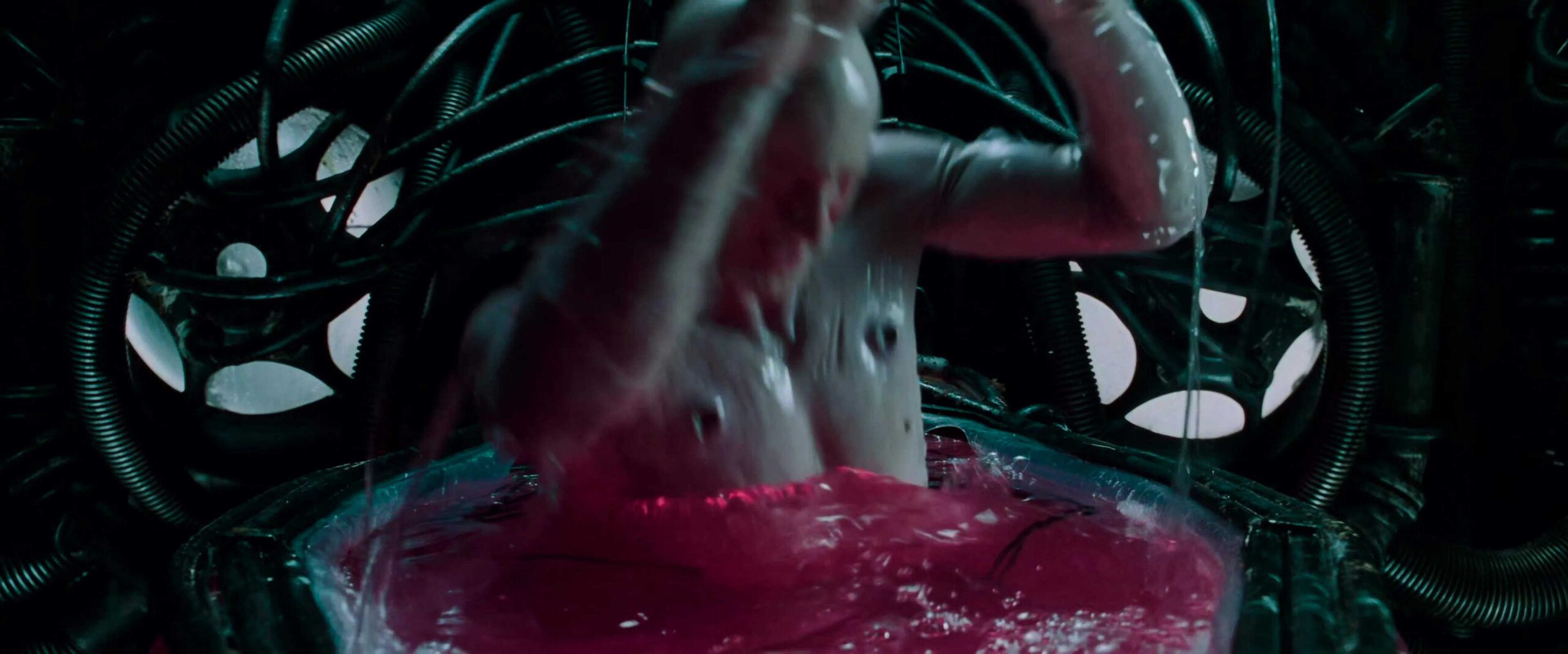 What is Campbell's Monomyth? A Hero Guide for Filmmakers 7 Neo emerges from a red fluid pod, surrounded by cables and machinery, covered in slime as he gasps for air.