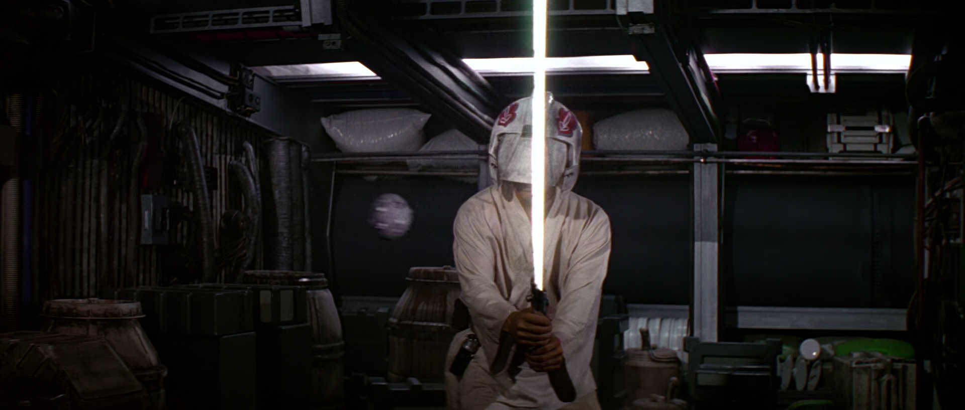 What is The Hero’s Journey? Story Structure Explained with Star Wars 7 Luke stands blindfolded aboard the Millennium Falcon, lightsaber drawn, while a remote training droid floats nearby.