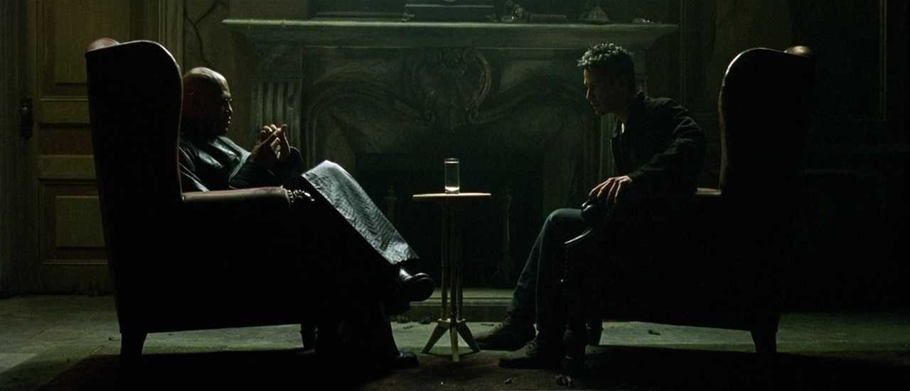 What is Campbell's Monomyth? A Hero Guide for Filmmakers 5 Morpheus and Neo sit across from each other in dark armchairs, lit dramatically, with a glass of water between them.