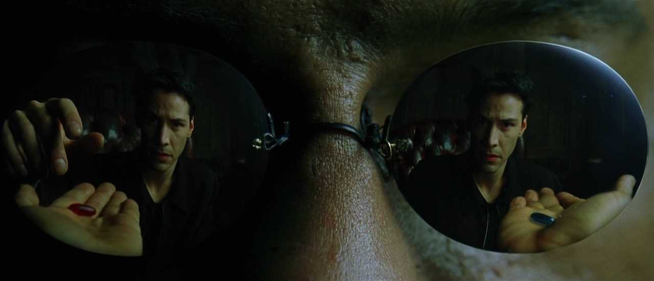 What is Campbell's Monomyth? A Hero Guide for Filmmakers 6 Close-up of Neo’s reflection in Morpheus’s glasses as he reaches for the red pill, with the blue pill in the other hand.