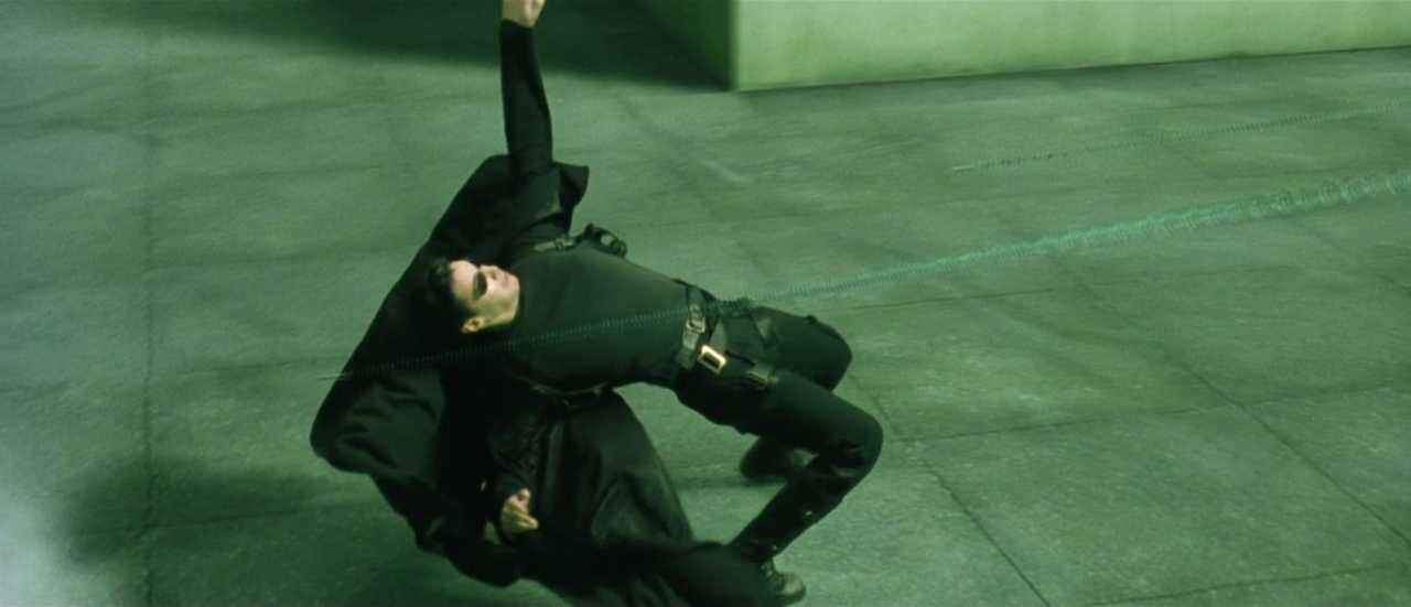 What is Campbell's Monomyth? A Hero Guide for Filmmakers 13 Neo leans back in slow motion as bullets fly past him on a rooftop, captured mid-dodge in a bullet time shot.