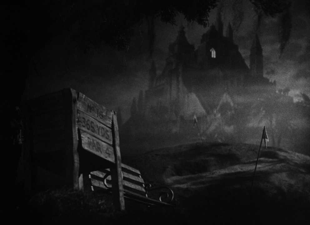 Symbolism in Film: Meaning, Types, and How It Works 7 Black-and-white shot of a “No Trespassing” sign in the foreground with a dark, castle-like mansion in the misty distance and one small window glowing.