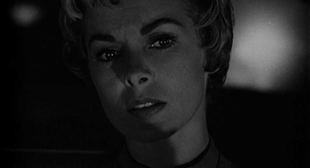 What is a Red Herring? Meaning & Examples from Film & Literature 2 Black-and-white close-up of Marion Crane seated in a car at night, her face partly lit and partly in shadow as she looks ahead tensely.