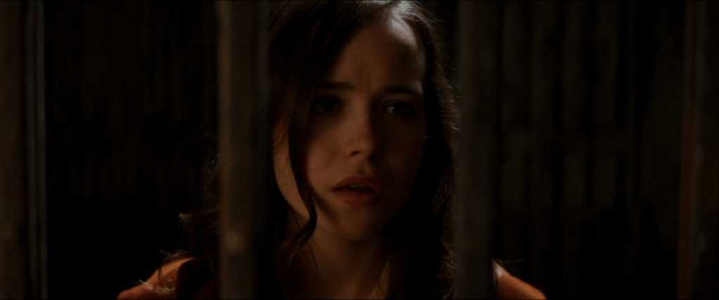 What is Allusion in Film? Meaning, Definition & Examples 2 Ariadne (played by Elliot Page) looks through a metal gate in a dimly lit scene, suggesting confusion or entrapment.