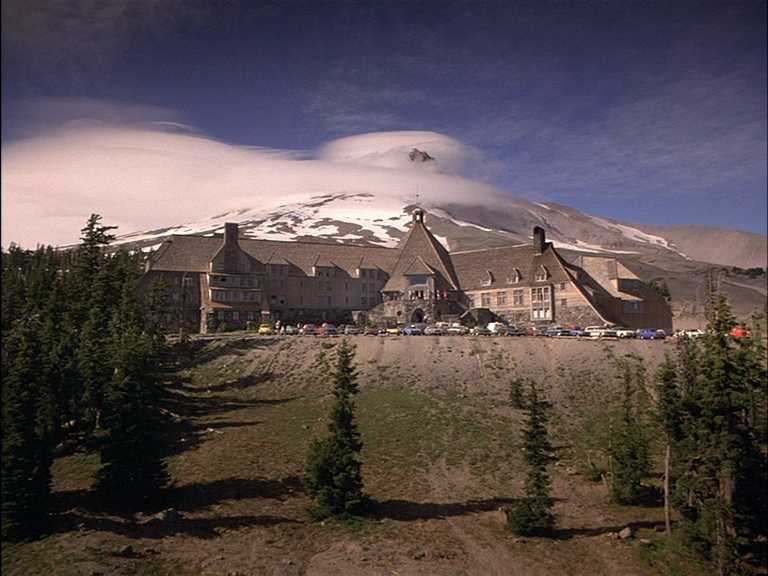 What Is the Setting in Film? Time, Place & Mood 7 A large mountain hotel sits in a remote landscape with forest and snow-covered peaks in the background.
