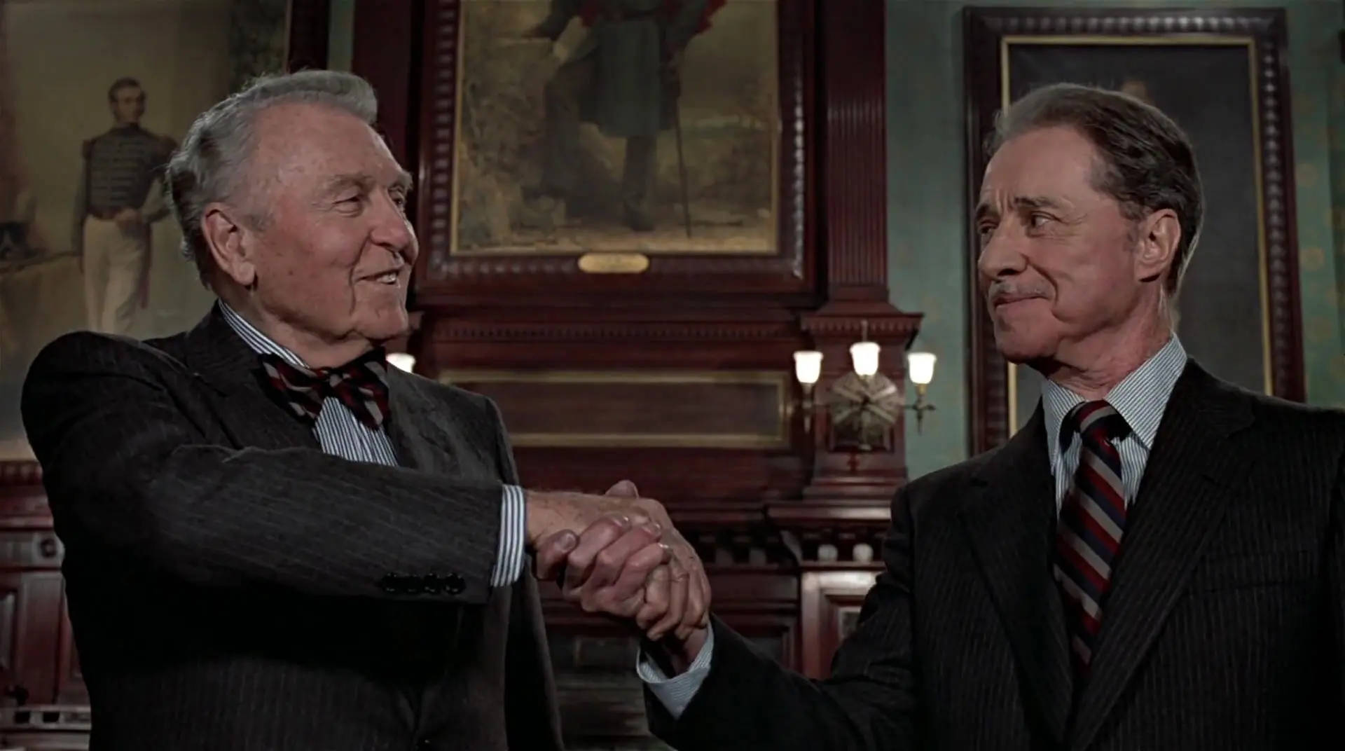 Peripeteia in Film. Definition, Meaning & Examples 4 Two older businessmen in suits shake hands in a wood-paneled office.