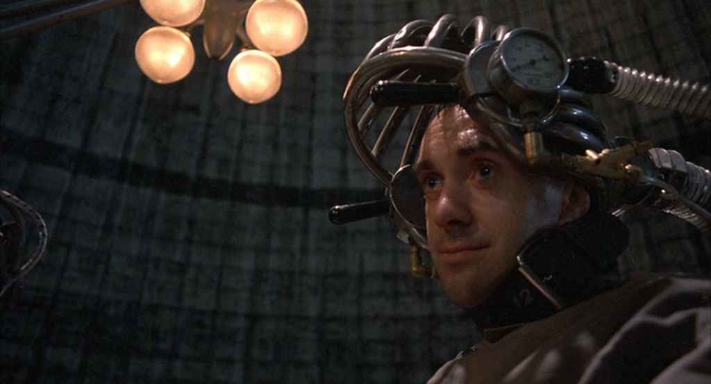 What is Tech Noir? Film Noir meets Dystopia. 4 Sam Lowry wears a strange metal device on his head inside a dark, industrial room in Brazil (1985)