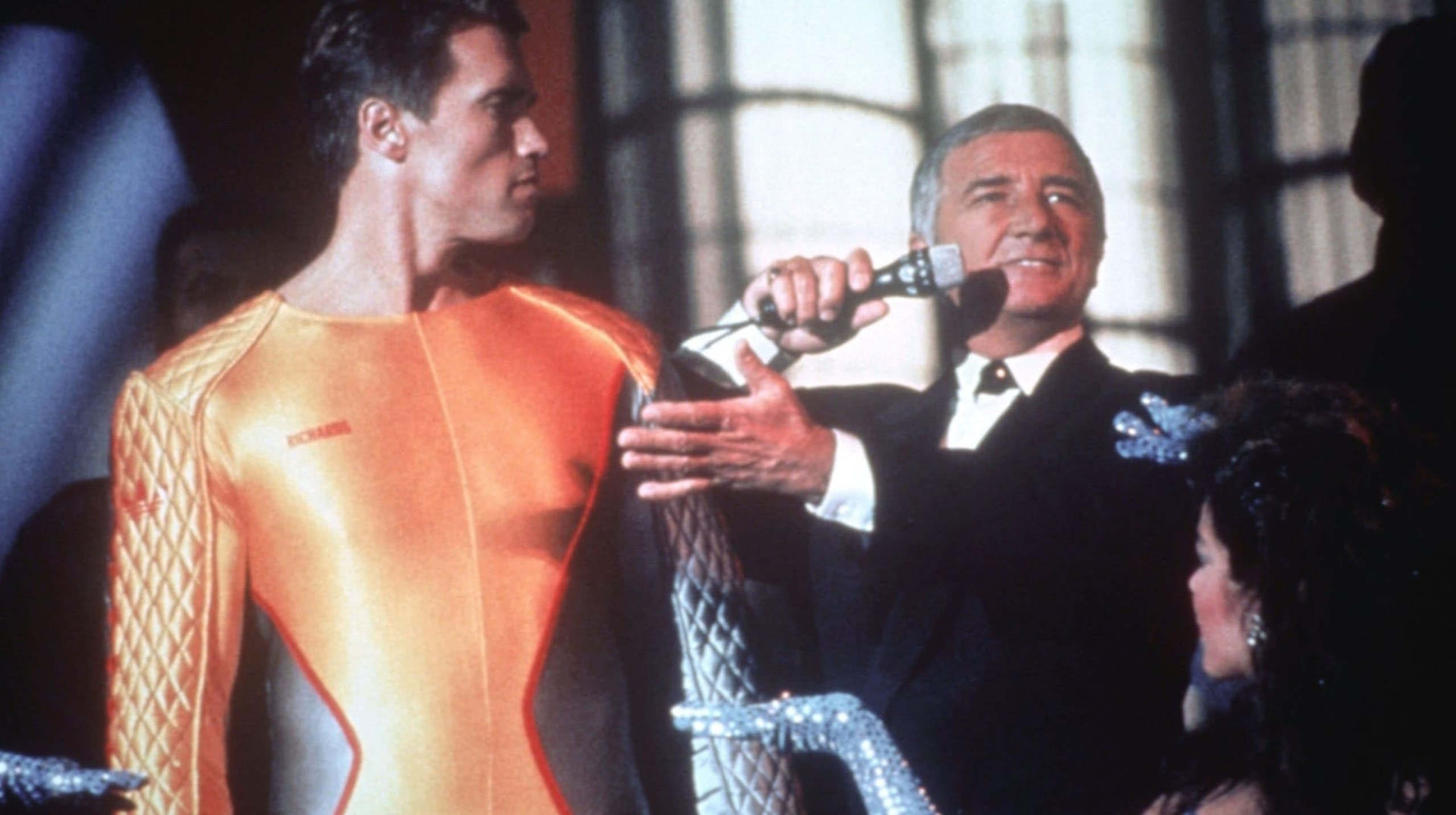 What is Tech Noir? Film Noir meets Dystopia. 7 Arnold Schwarzenegger stands in a gold jumpsuit as a host interviews him onstage in The Running Man (1987)