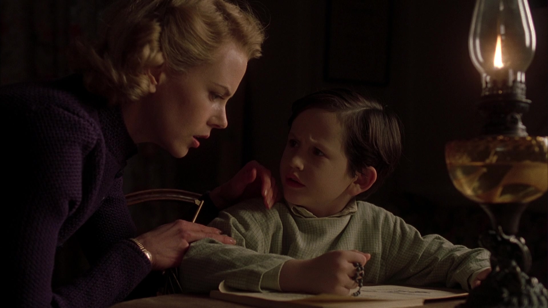 What is Anagnorisis? Definition & Examples from Film 6 Grace Stewart speaks urgently to her son in lamplight, showing tension and fear.