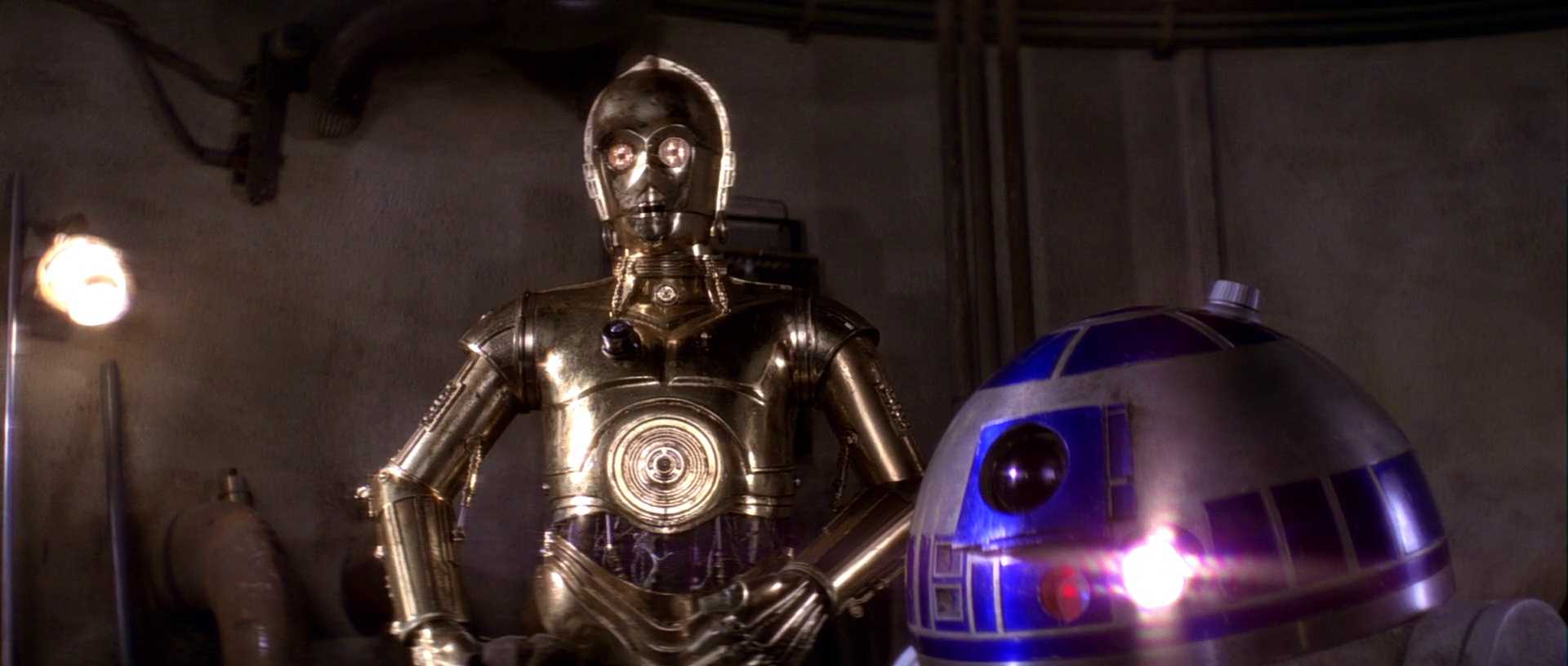 What Is a Stock Character? Definition & Film Examples 6 C-3PO stands with one hand on his hip beside R2-D2 inside a dim spacecraft interior.