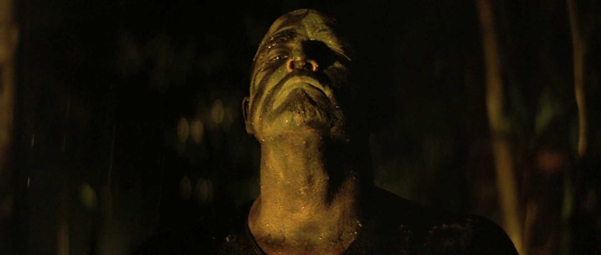 Analogy Explained: Meaning, Function + Film Examples 9 Colonel Kurtz stands in darkness, covered in mud and lit from below in Apocalypse Now