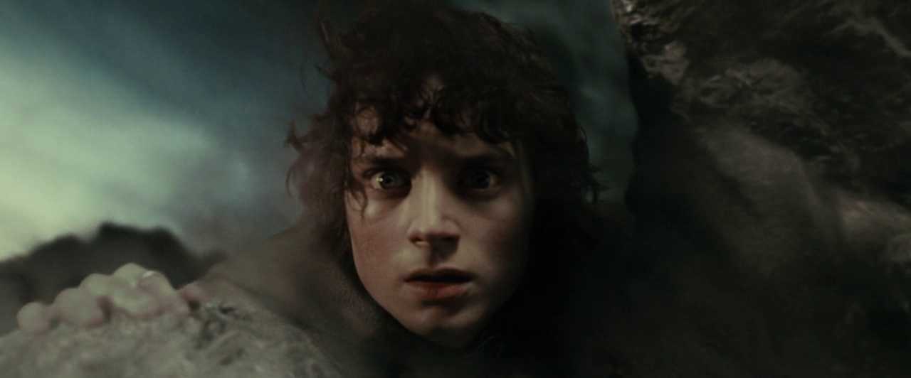 What Is a Stock Character? Definition & Film Examples 2 Close-up of Frodo hiding against rocks in a dark, smoky landscape, looking frightened and trapped.