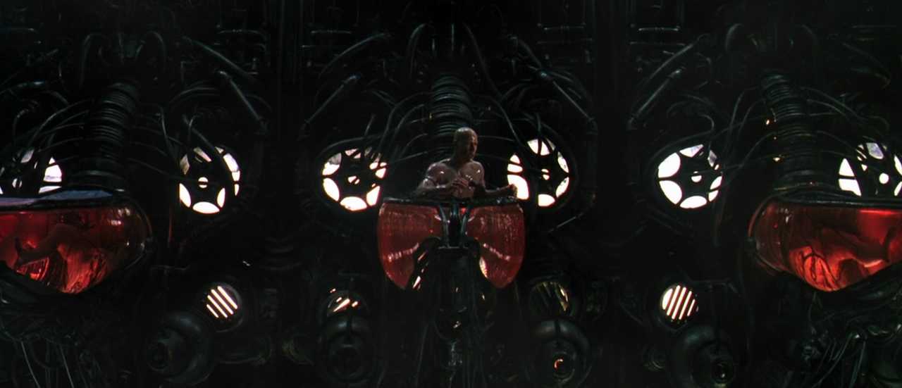 Analogy Explained: Meaning, Function + Film Examples 8 Neo emerges from a red bio-pod surrounded by machinery after waking from the simulated world in The Matrix