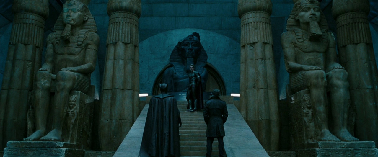 What is an Anti-Villain? Definition & Examples from Film 3 Ozymandias stands at the top of a wide staircase inside a temple-like room with huge Egyptian statues, while Rorschach and Nite Owl confront him from below.
