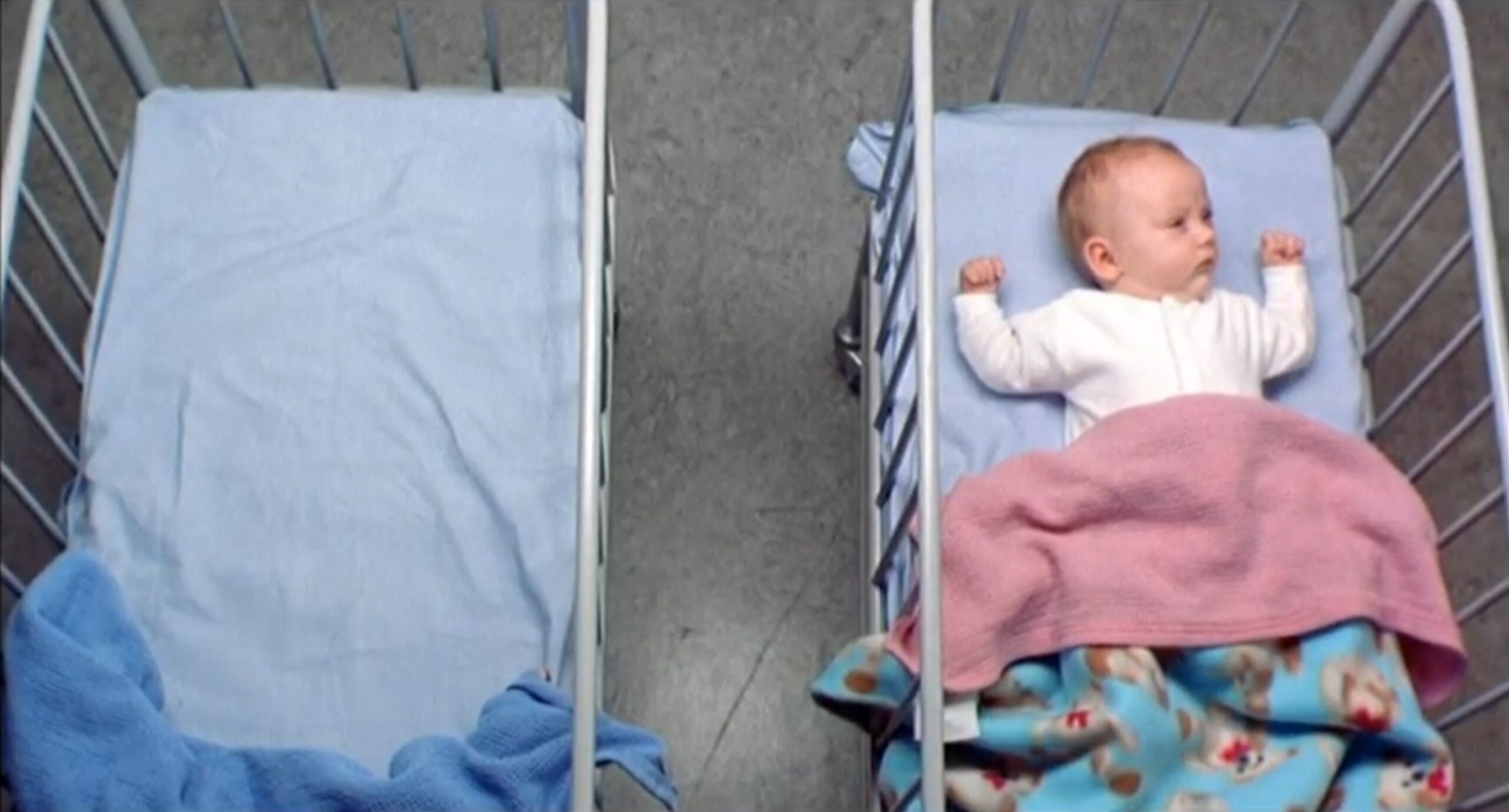 What Is Symmetrical Balance in Art & Film? Definition & Examples 11 Overhead shot of two hospital-style cribs; the left crib is empty and the right crib holds a baby under blankets.