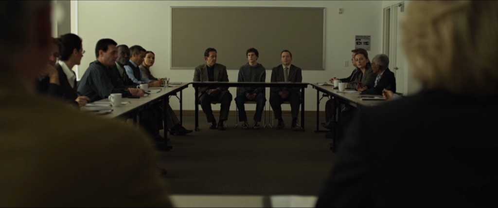 What is Characterization? Elements Defining Your Characters 15 A wide shot shows a deposition room with lawyers and witnesses seated around two long tables facing each other.