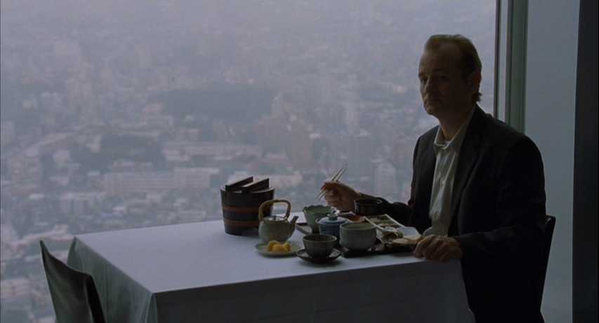What is a Soliloquy? Definition & Examples from Plays & Film 2 Bob Harris sits alone at a white table by a floor-to-ceiling window with a hazy Tokyo skyline behind him, with a Japanese meal set in front of him.