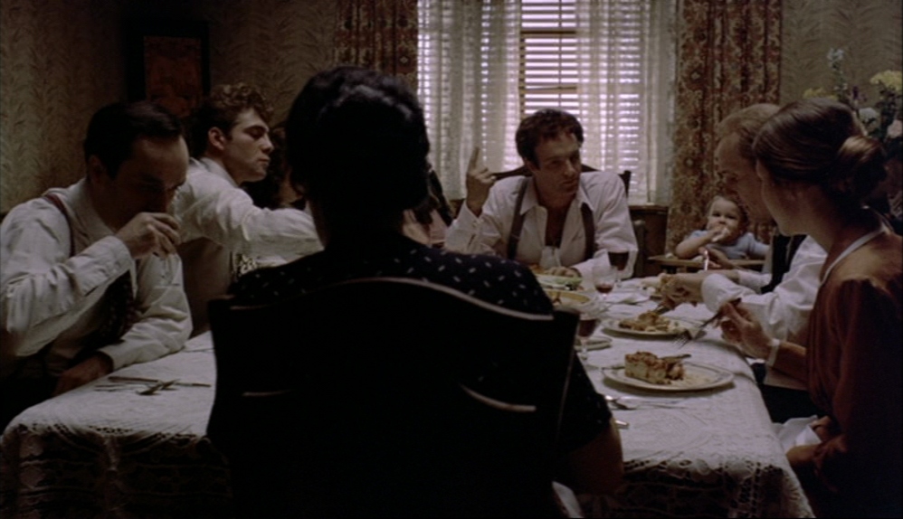 What is Characterization? Elements Defining Your Characters 17 A group sits around a dinner table in a dim room, with one figure in the foreground seen from behind while others eat and talk under a window with blinds.