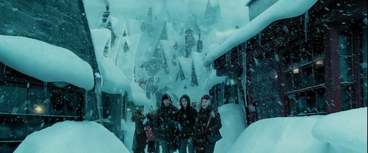 What is a Round Character? Definition & Film Examples 5 Harry walks down a snowy street in Hogsmeade with Hermione and Ron beside him, while snow falls heavily and the distant Hogwarts castle rises in the background.