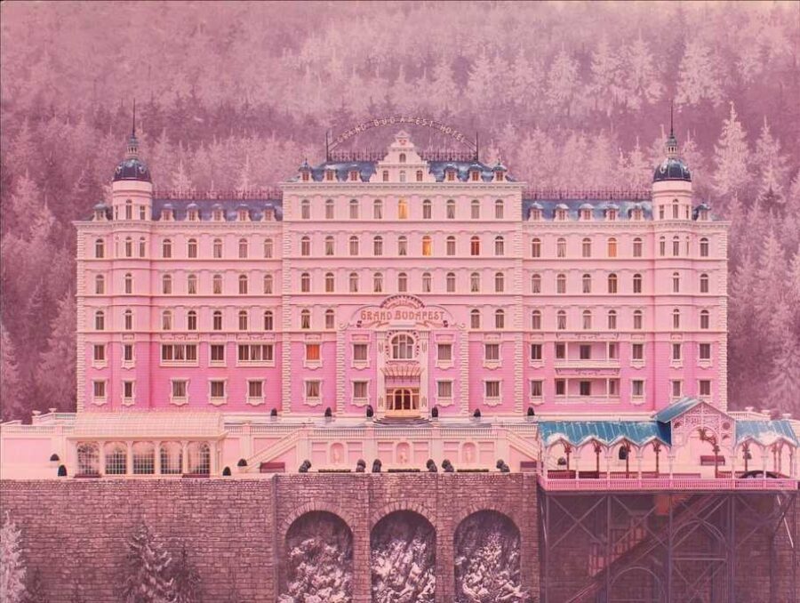 What is Cinematography? Definition, How it Works & Tools of the Trade 7 A symmetrical, pink hotel building framed against a pastel forest in The Grand Budapest Hotel