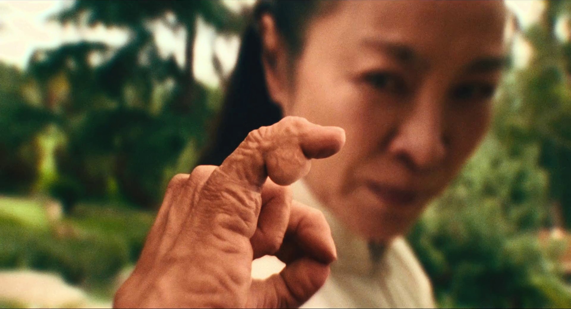 Film Theory: Definition, Discourses, and How to Use It 15 A close-up of a hand with bent, sausage-like fingers pointing at a woman’s face in Everything Everywhere All At Once