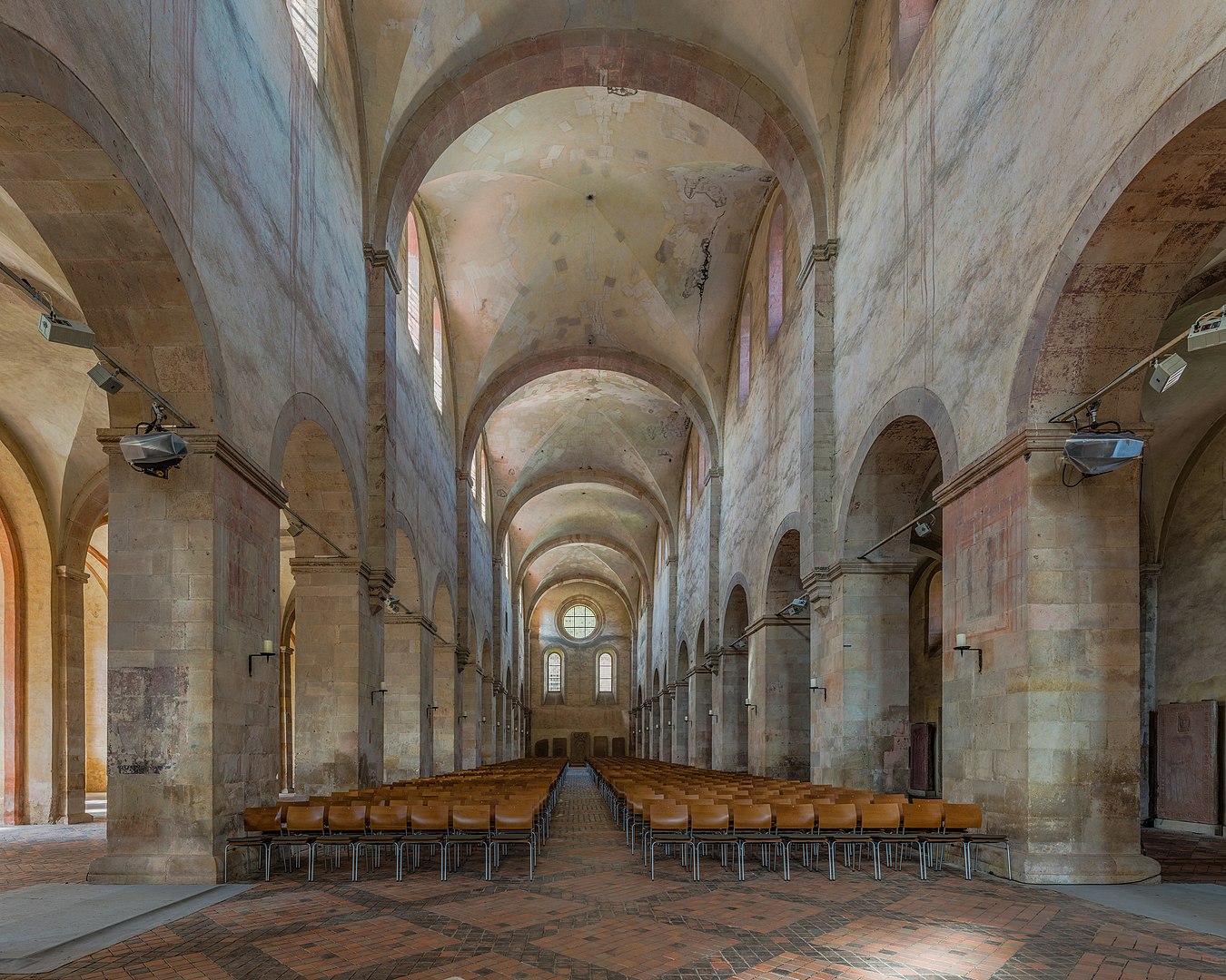 What Is Gothic Art? Definition, History & Examples 21 Interior view of Kloster Eberbach’s Romanesque basilica with stone arches, vaulted ceilings, and rows of wooden chairs