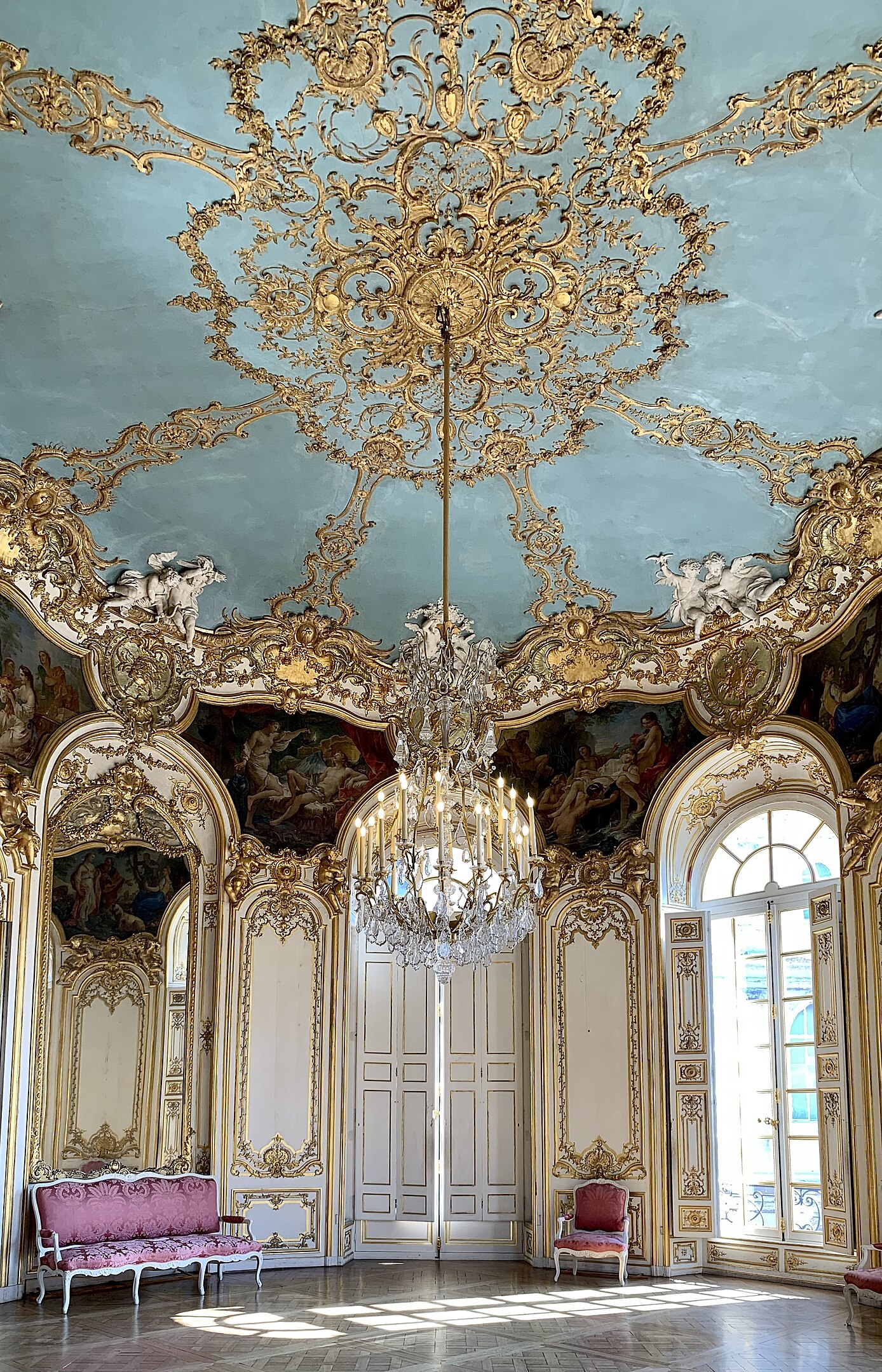 What Is Rococo Art? Definition, Style, and Legacy 9 Ornate Rococo salon with blue ceiling, gold stucco, chandelier, and pastel furniture