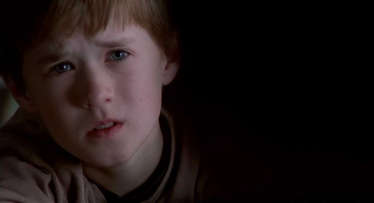 100+ Best Movie Quotes of All Time: The Definitive List 8 A close-up of a boy looking scared and emotional, half-lit in darkness.