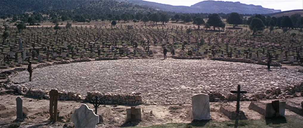 What Is a Spaghetti Western? Definition, History & Style 4 Wide shot of three men in circular graveyard arena