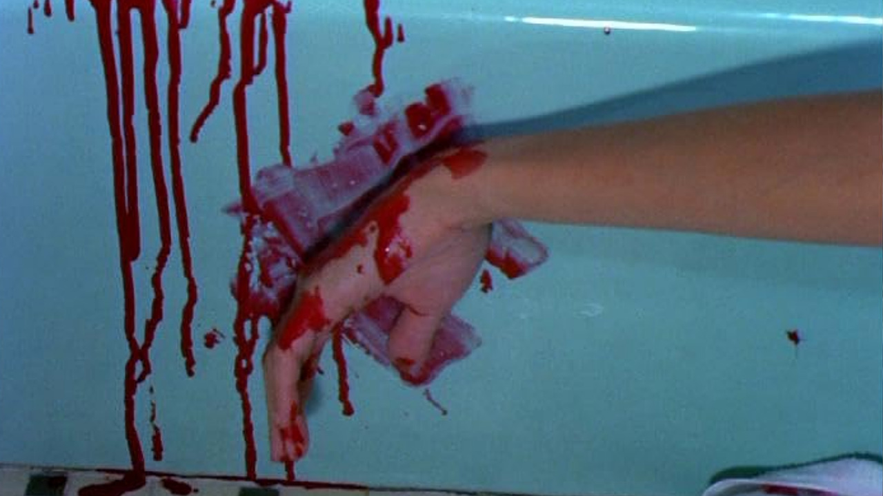 What Is Exploitation Cinema? Definition & Key Examples 10 Close-up of a bloody hand smearing red liquid across a light blue bathtub in Blood Feast (1963).