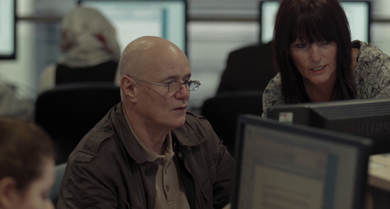 What Is the Difference Between Formalism and Realism in Film? 5 A man and a caseworker at a computer terminal in a job center
