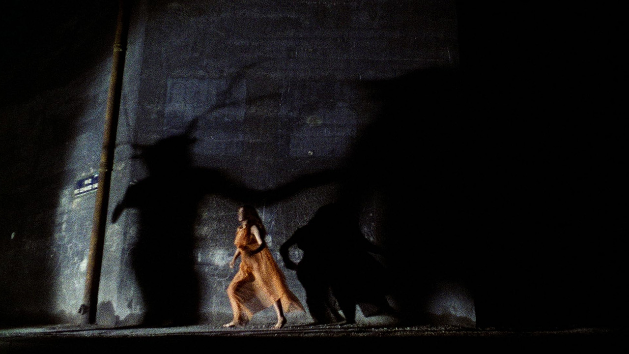What Is Erotic Cinema? Definition, Genre & Global Examples 5 A woman in an orange dress walks past monstrous shadows in The Nude Vampire (1970, Les Films ABC)