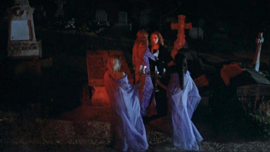 What Is Eurocult Cinema? Definition, Directors & Legacy 4 Four women in robes gather in a red-lit graveyard at night