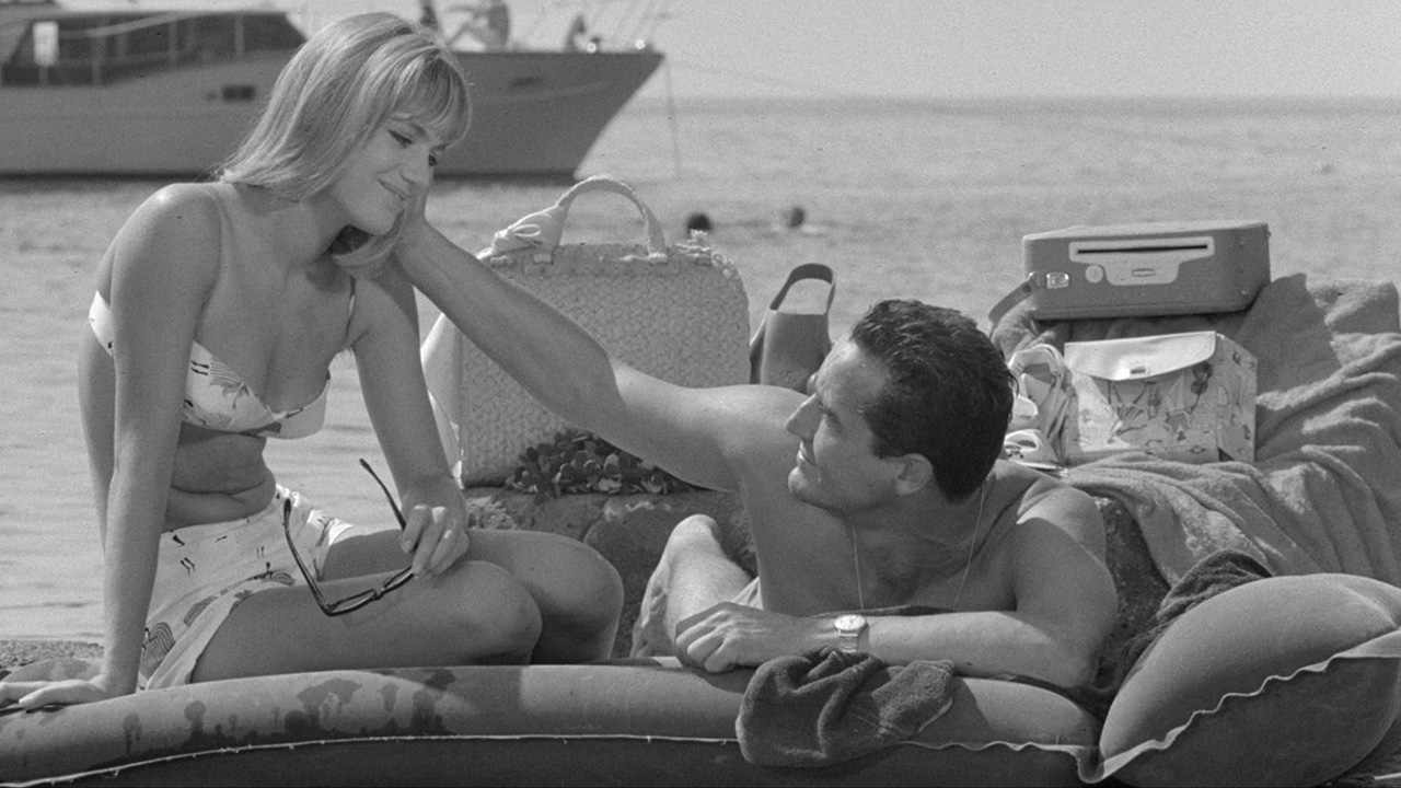 What Is Commedia all’italiana? Definition & Film Style 3 Man and woman lounging on a beach raft in Il sorpasso (1962)