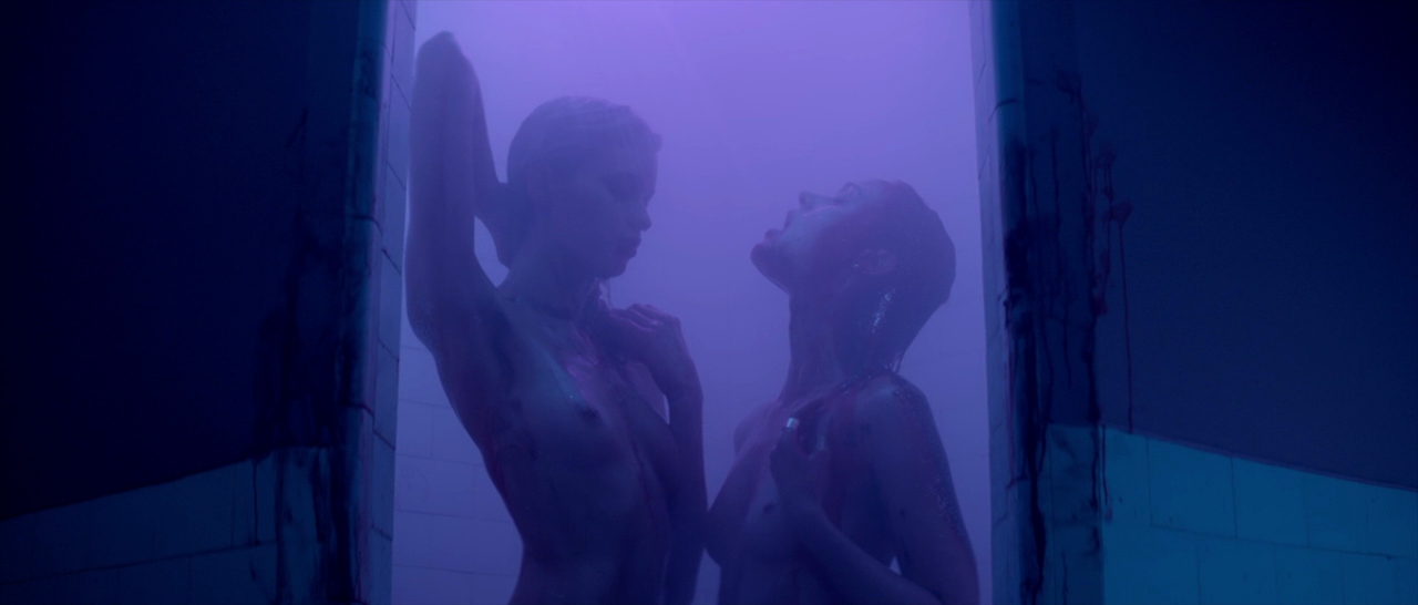 What Are Giallo Films? Definition, History & Key Examples 13 Two women covered in blood under purple lighting in a shower scene from The Neon Demon (2016)