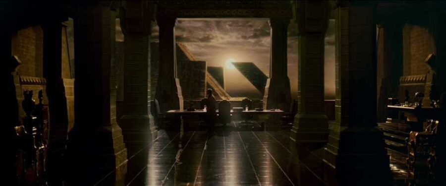 Similarities & Differences Between Science Fiction & Fantasy in Film Explained 4 Silhouetted figures sit in a vast office chamber with geometric windows framing a dystopian sunset