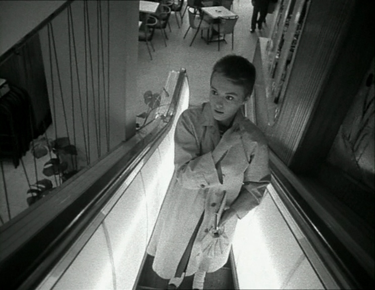 What Is an Arthouse Film? Definition, Examples & Style 4 A woman in a trench coat rides an escalator in Breathless (1960), filmed in black and white