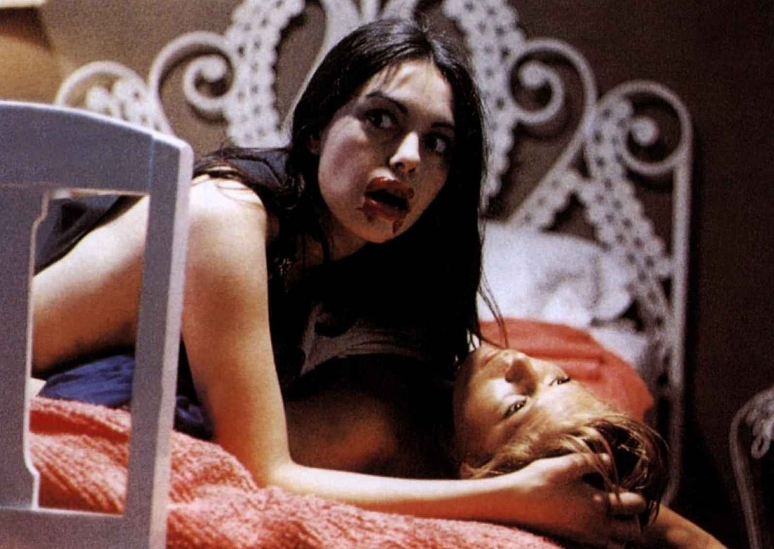 What Is a B-Movie? Definition & Film History 2 Woman with blood on her mouth lies on top of another woman in bed, looking off-screen.