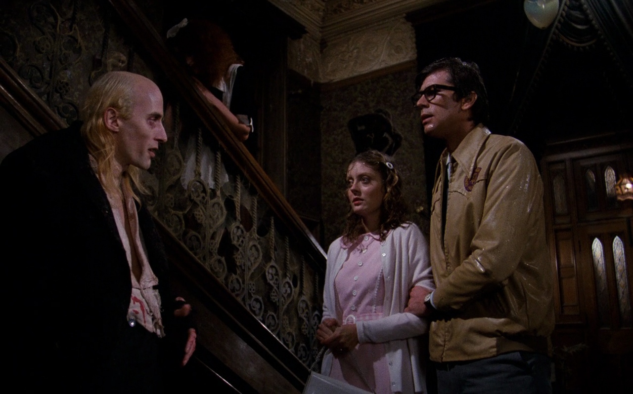 Cult Classic Films: What Makes a Movie a Cult Hit? 3 Riff Raff speaks to a nervous Brad and Janet inside the dark gothic mansion in The Rocky Horror Picture Show.